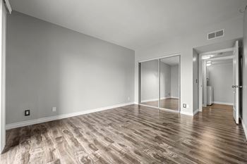 A room with wooden flooring and a sliding door.